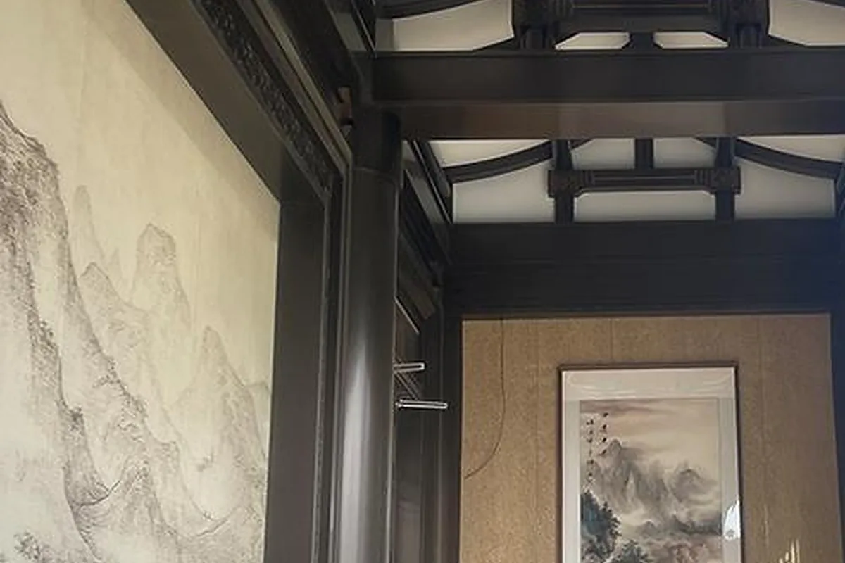Dark decorative metal door frame surrounding an interior artwork panel