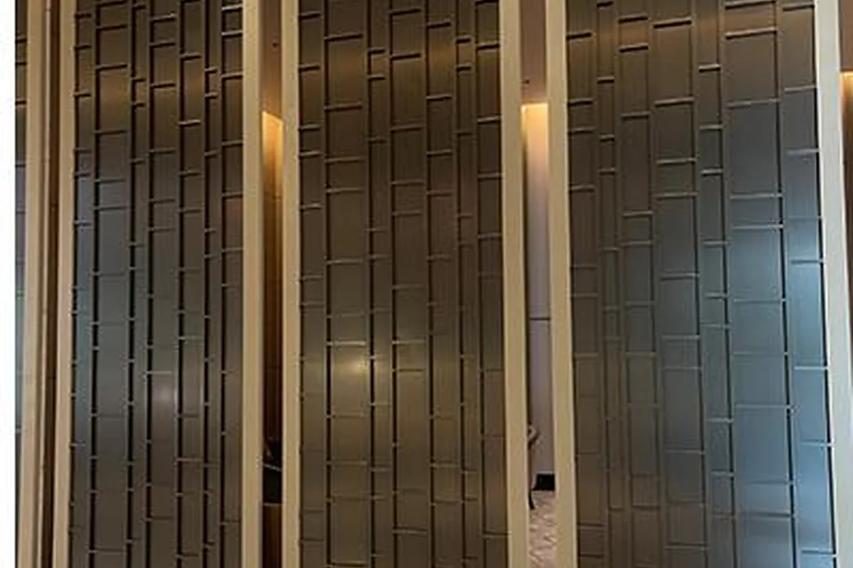 Bronze-tone decorative metal screens and wall cladding in a lobby interior