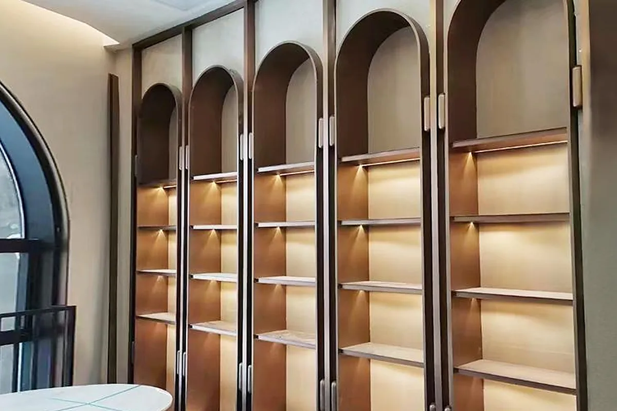 Warm metallic decorative wall panels and arched display niches in a residential interior